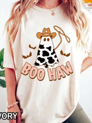 Boo Haw Halloween T-Shirt - Comfort Colors Western Cow Print Boo Haw Halloween T-Shirt featuring a cow in a cowboy hat throwing a rope