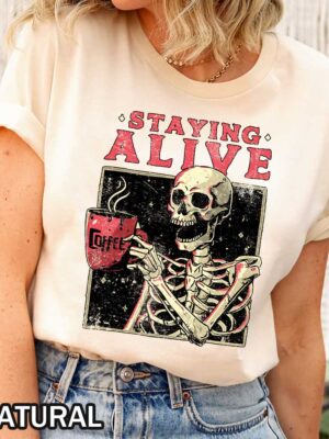 Unisex Halloween Staying Alive T-Shirt Skeleton Coffee Mug Unisex Halloween Staying Alive T-Shirt Featuring Skeleton Holding Coffee Mug