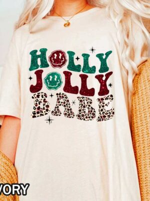 Christmas Holly Jolly Babe Comfort Colors T-Shirt Christmas Holly Jolly Babe T-Shirt Featuring Smiley Face with Glitter and Leopard Print